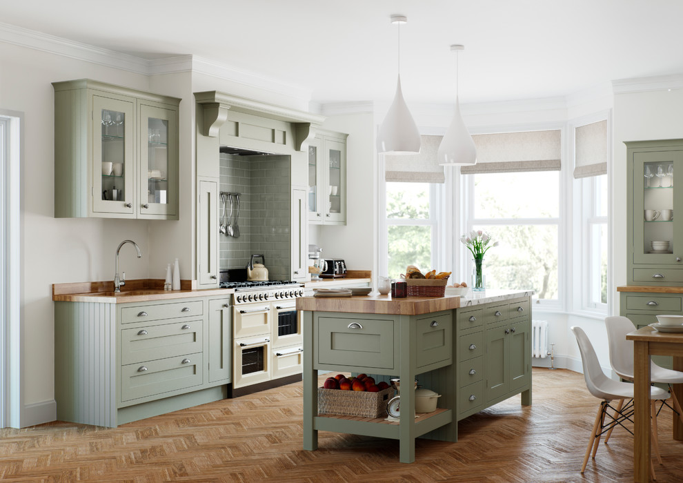 This is an example of a transitional single-wall eat-in kitchen in Manchester with an undermount sink, shaker cabinets, green cabinets, wood benchtops, green splashback, panelled appliances, medium hardwood floors, with island, brown floor and brown benchtop.