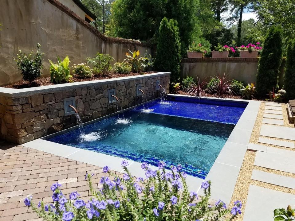 Mid-sized contemporary backyard rectangular pool in Birmingham with a water feature and brick pavers.