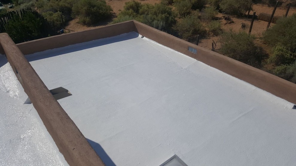 Mid-sized transitional two-storey adobe brown exterior in Albuquerque with a flat roof.