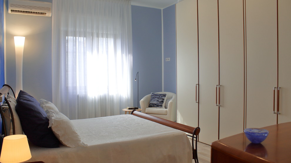 На фото: большая хозяйская спальня в современном стиле с синими стенами и полом из керамогранита с