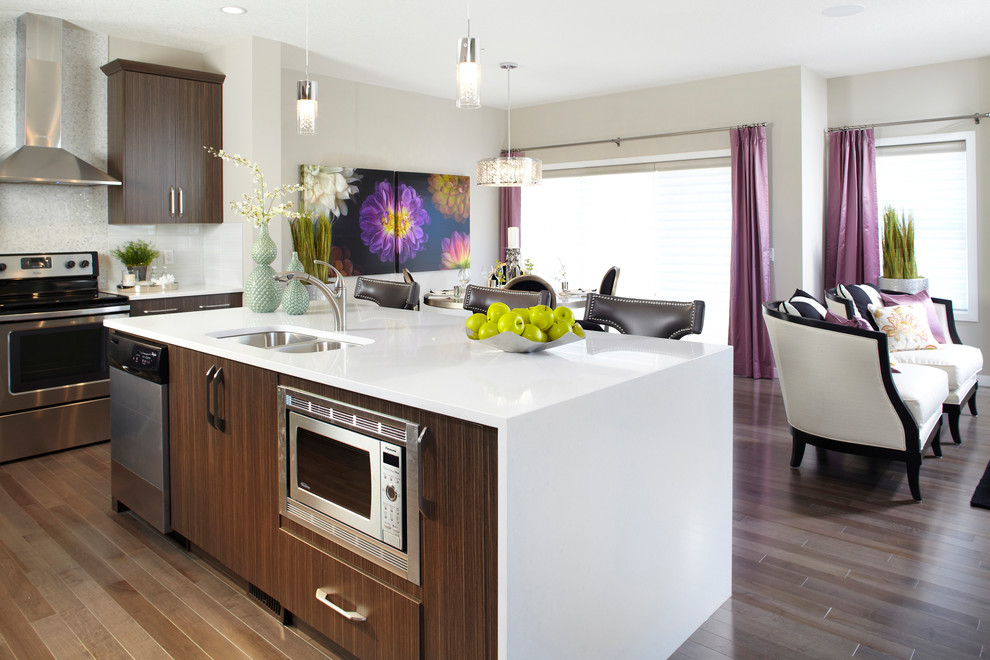 Photo of a contemporary kitchen in Calgary with flat-panel cabinets, an undermount sink and dark wood cabinets.