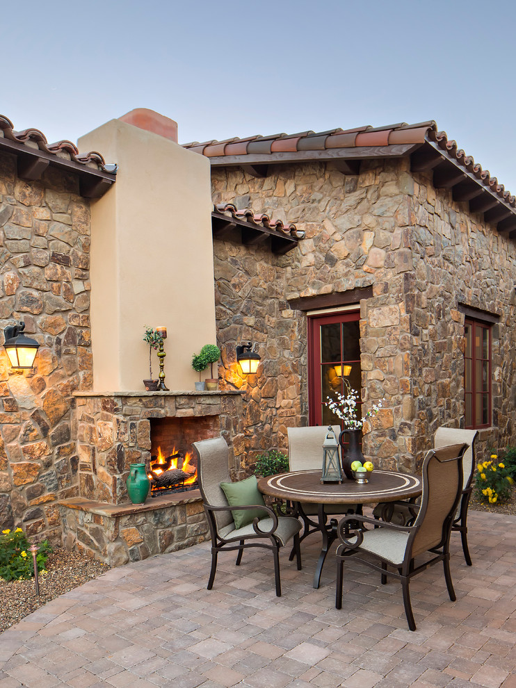 This is an example of a mediterranean patio in Phoenix with no cover and with fireplace.