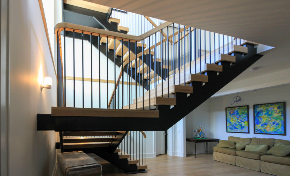 Ejemplo de escalera suspendida moderna extra grande con escalones de madera, barandilla de varios materiales y machihembrado