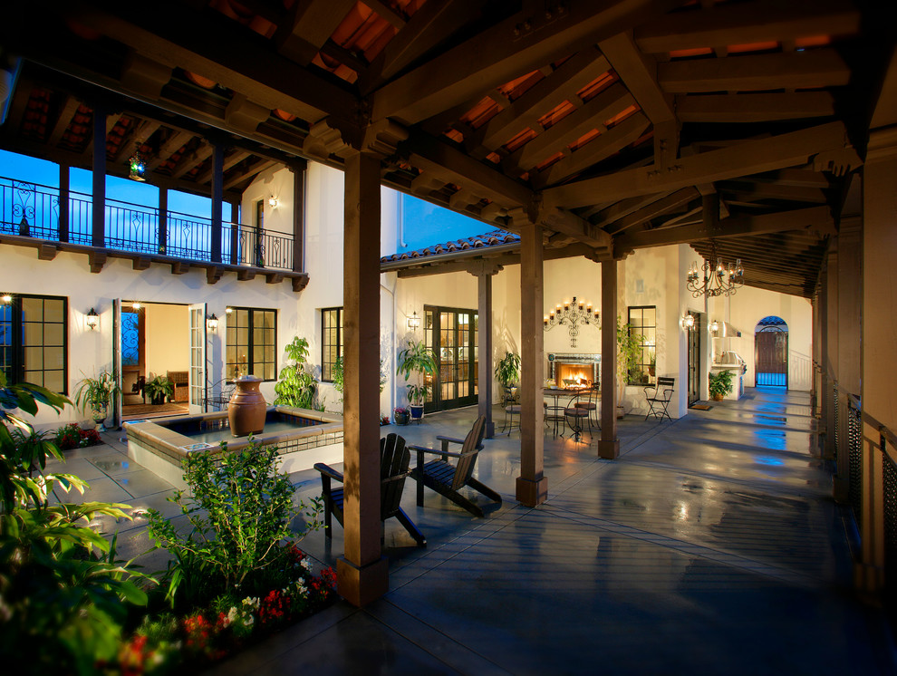 Photo of a mediterranean verandah in Los Angeles with a water feature, a roof extension and tile.