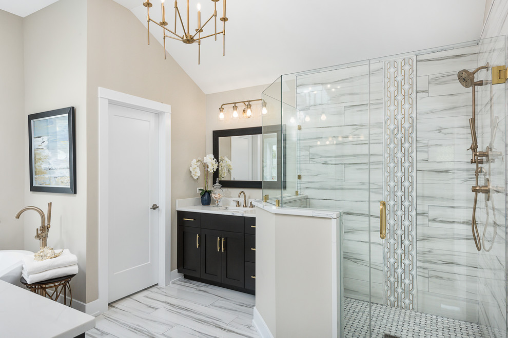 This is an example of a mid-sized contemporary master bathroom in Chicago with shaker cabinets, black cabinets, a freestanding tub, a corner shower, gray tile, white tile, porcelain tile, beige walls, porcelain floors, an undermount sink, quartzite benchtops, white floor, a hinged shower door and white benchtops.