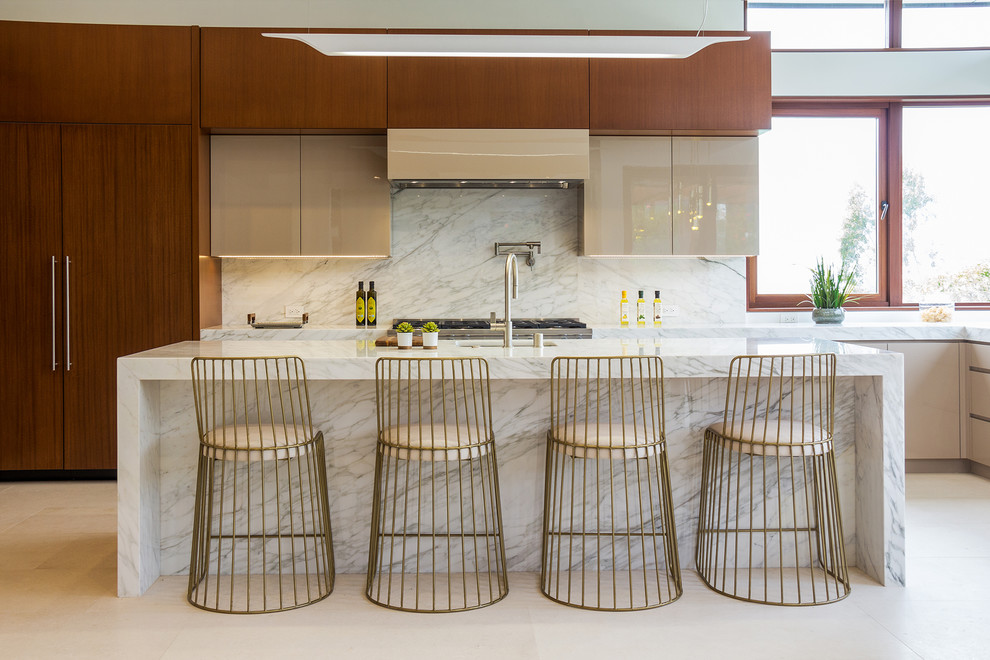 Photo of a midcentury kitchen in Los Angeles with an undermount sink, flat-panel cabinets, medium wood cabinets, white splashback, with island and beige floor.