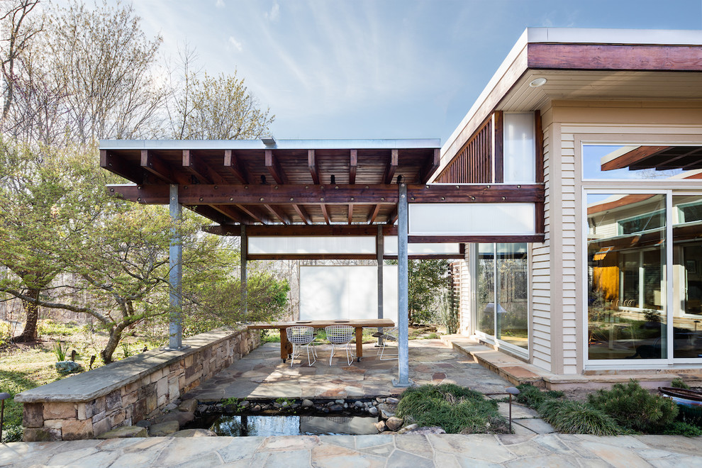 Inspiration for a large modern beige one-story wood flat roof remodel in Raleigh