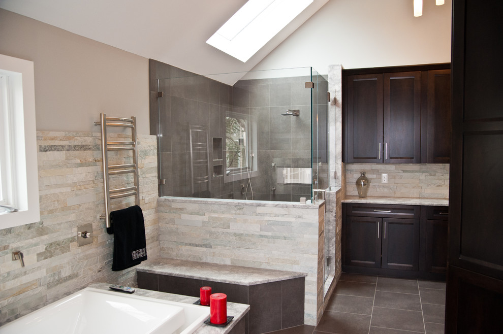 Design ideas for a large transitional master bathroom in New York with shaker cabinets, dark wood cabinets, a drop-in tub, a corner shower, beige tile, gray tile, stone tile, ceramic floors, granite benchtops and grey walls.