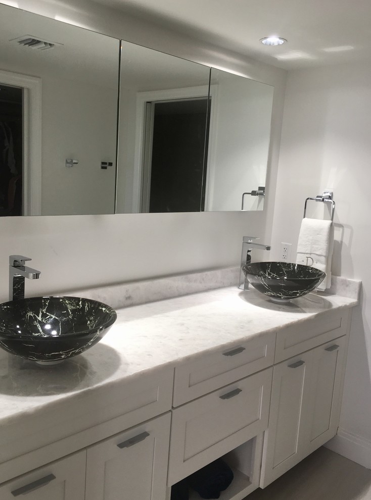 Photo of a mid-sized transitional bathroom in Miami with recessed-panel cabinets, white cabinets, white walls, a vessel sink and marble benchtops.