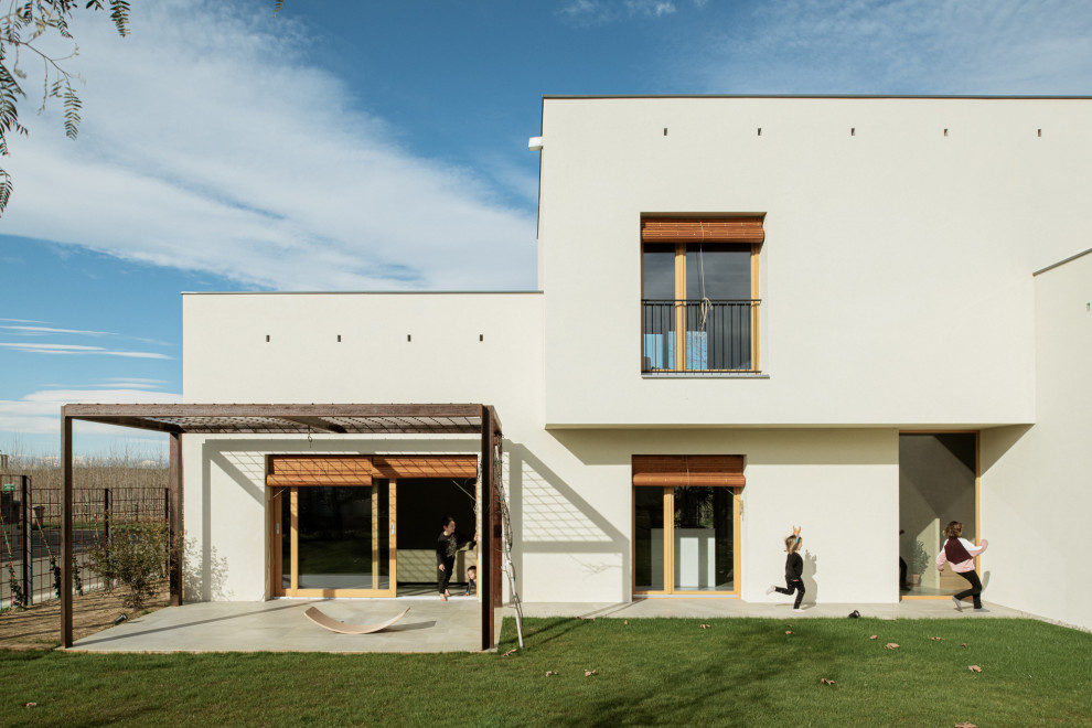 Foto della facciata di una casa grande beige mediterranea a due piani con rivestimento con lastre in cemento, copertura in tegole e tetto marrone