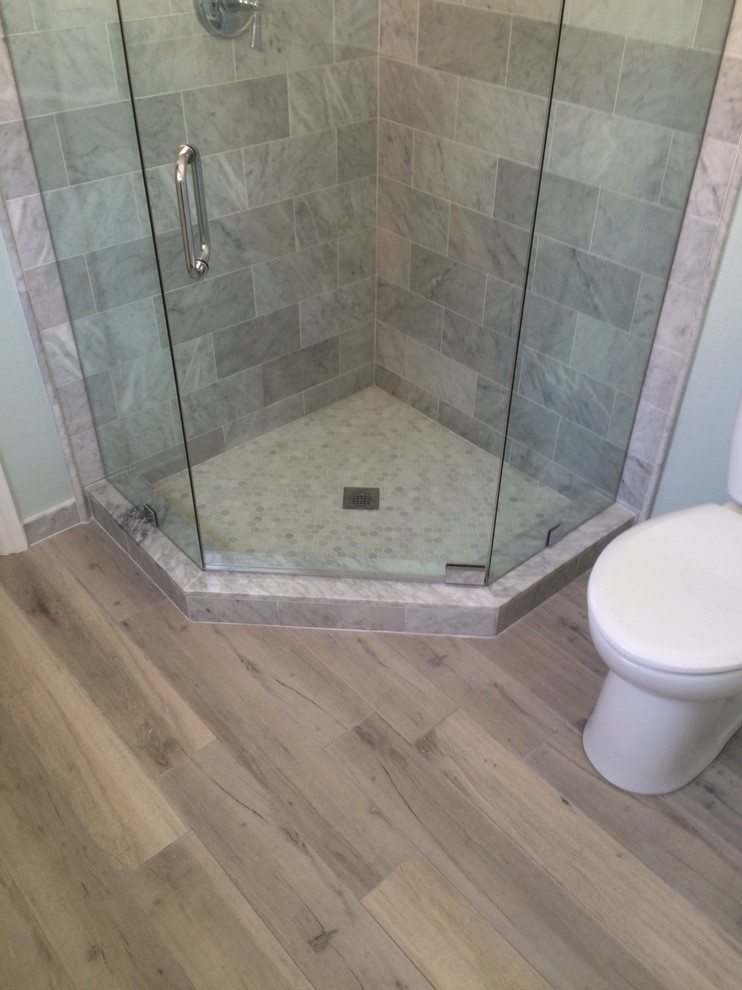 Small beach style master bathroom in Orange County with recessed-panel cabinets, a corner shower, a one-piece toilet, white tile, stone tile, green walls, an undermount sink, marble benchtops and medium hardwood floors.