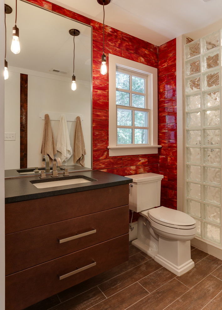 Photo of a small country bathroom in Raleigh with an undermount sink, flat-panel cabinets, medium wood cabinets, granite benchtops, an open shower, a two-piece toilet, glass tile, red walls, ceramic floors and red tile.