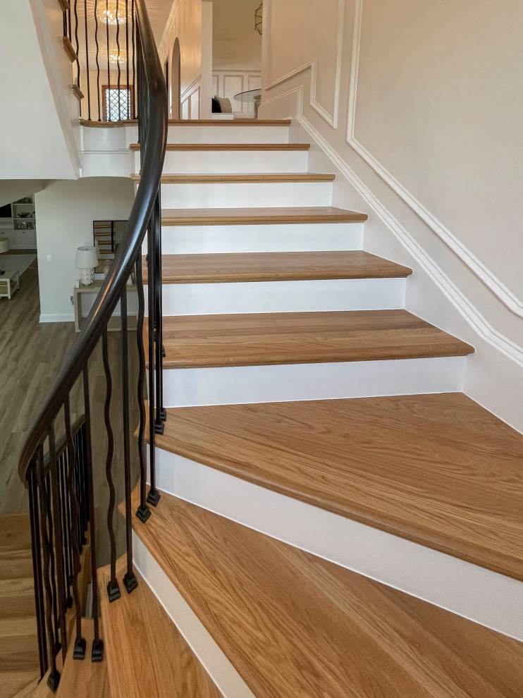 This is an example of a large transitional wood floating staircase in DC Metro with painted wood risers, mixed railing and decorative wall panelling.