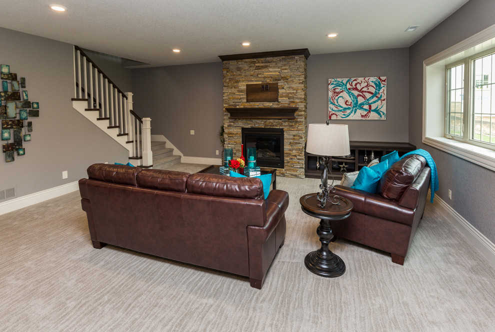 Inspiration for a transitional walk-out carpeted basement remodel with gray walls and a stone fireplace