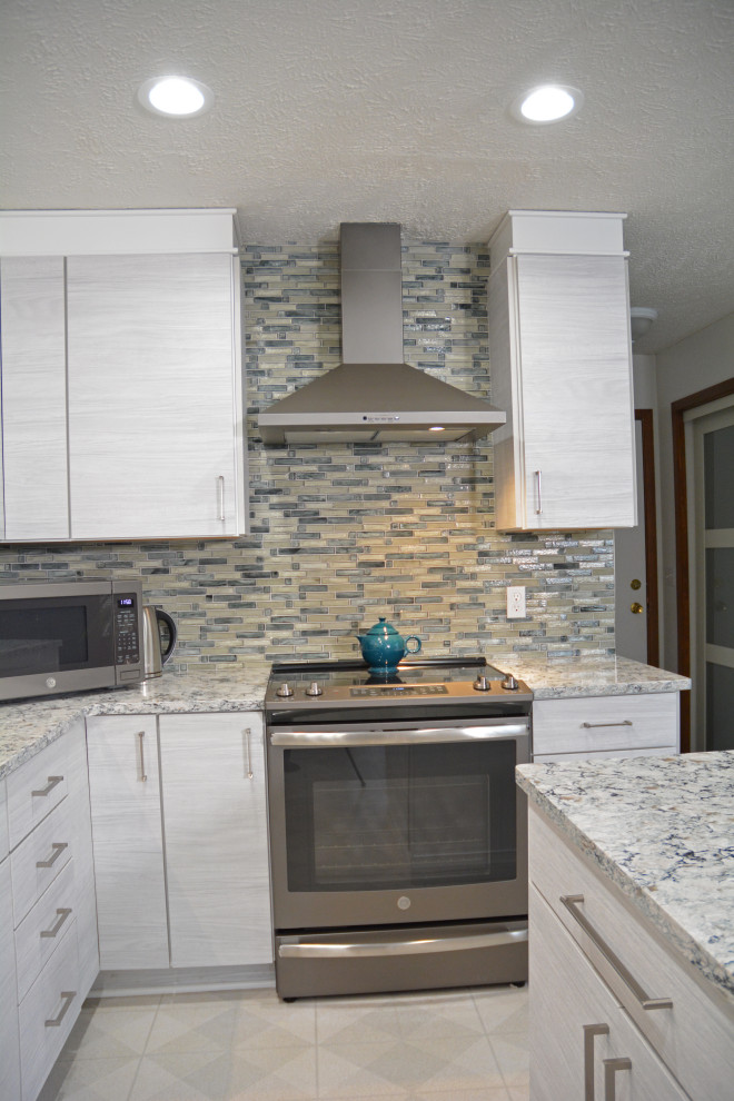 Photo of a mid-sized contemporary l-shaped separate kitchen in Other with an undermount sink, flat-panel cabinets, white cabinets, quartzite benchtops, grey splashback, glass tile splashback, stainless steel appliances, with island, beige floor and multi-coloured benchtop.