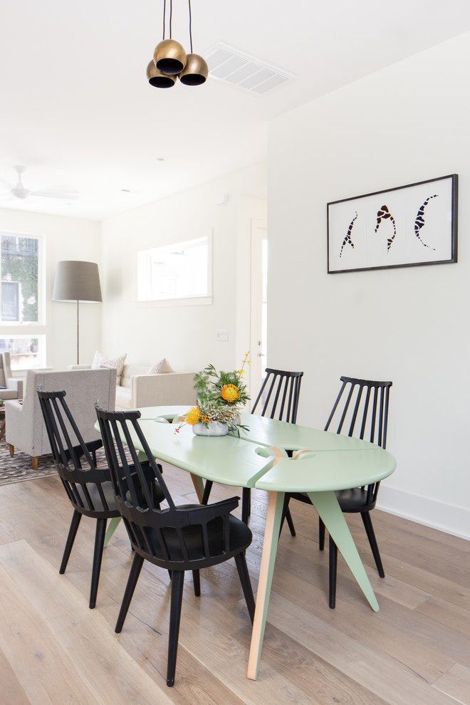 This is an example of a scandinavian dining room in Charleston with white walls and light hardwood floors.