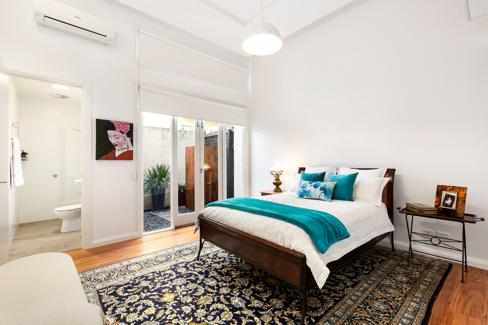 Photo of a mid-sized contemporary master bedroom in Melbourne with white walls, medium hardwood floors, no fireplace and white floor.