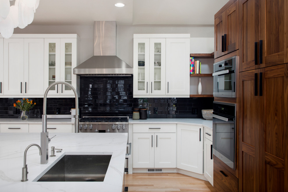 Inspiration for a mid-sized contemporary galley medium tone wood floor eat-in kitchen remodel in Miami with an undermount sink, shaker cabinets, medium tone wood cabinets, quartz countertops, white backsplash, subway tile backsplash, stainless steel appliances, an island and white countertops