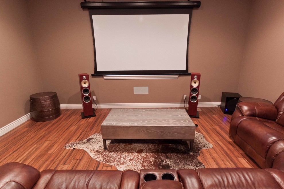 Photo of a large arts and crafts enclosed home theatre in San Francisco with brown walls, bamboo floors and a projector screen.