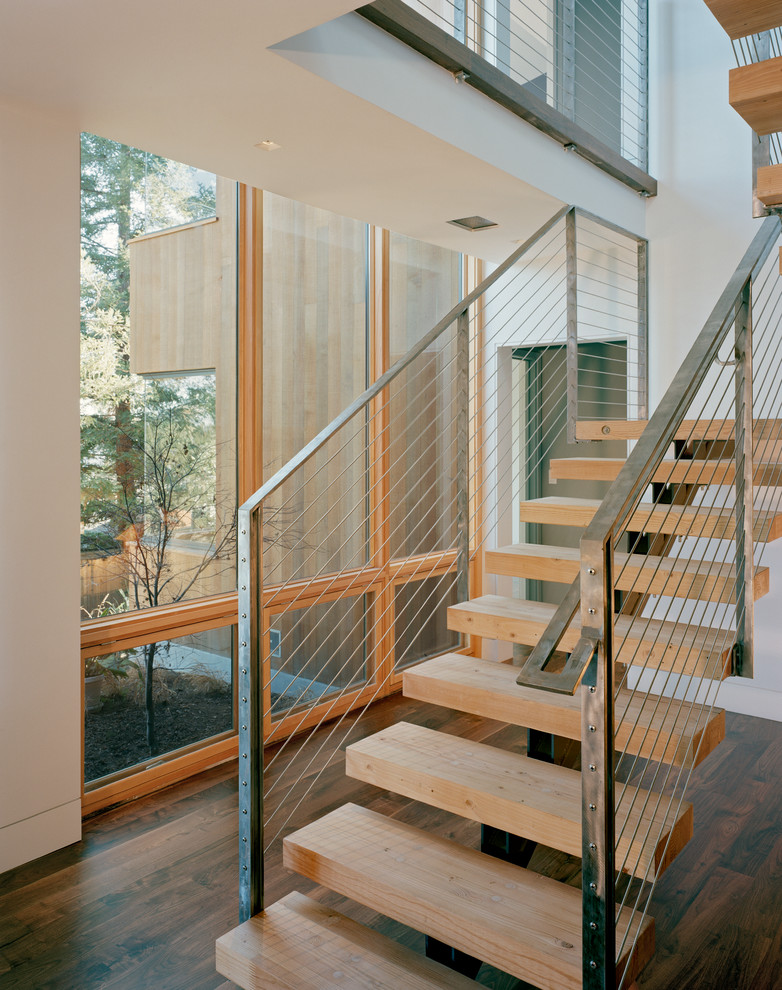Design ideas for a small modern wood u-shaped staircase in San Francisco with open risers, metal railing and wood walls.
