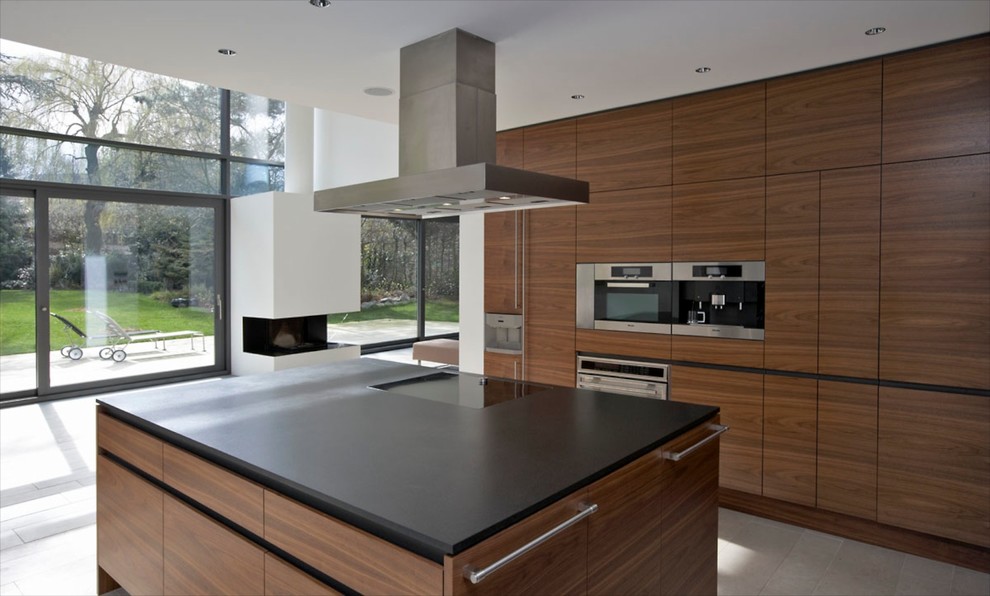 Large contemporary open plan kitchen in Dortmund with flat-panel cabinets, dark wood cabinets, panelled appliances and with island.