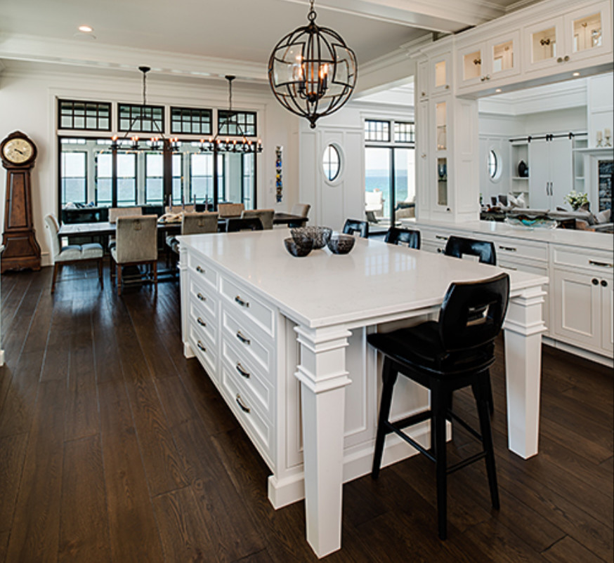 Large transitional galley dark wood floor and brown floor open concept kitchen photo with recessed-panel cabinets, white cabinets, white backsplash, two islands, stainless steel appliances and a double-bowl sink