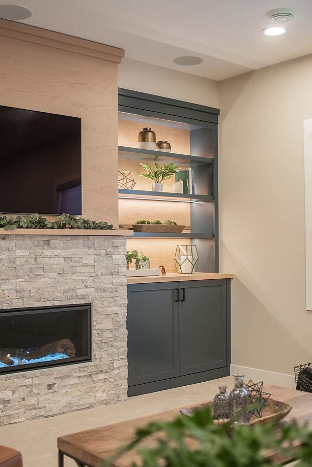 Photo of a large scandi open plan living room in Minneapolis with beige walls, medium hardwood flooring, a standard fireplace, a stacked stone fireplace surround, a built-in media unit and brown floors.