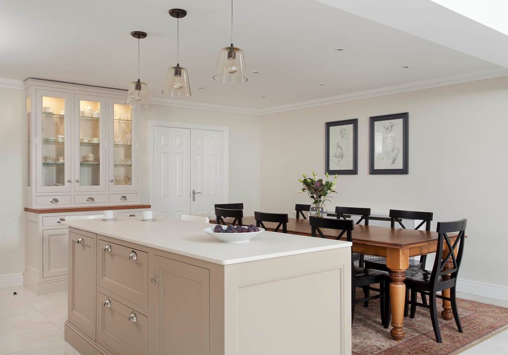 Design ideas for a large classic single-wall open plan kitchen in Dublin with a submerged sink, beaded cabinets, beige cabinets, quartz worktops, beige splashback, stone slab splashback, stainless steel appliances, porcelain flooring and an island.