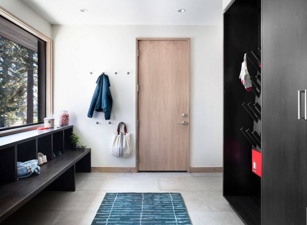 This is an example of a large modern mudroom in San Francisco with white walls, ceramic floors, a single front door and a light wood front door.