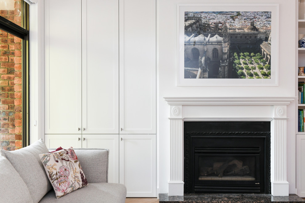 Inredning av ett klassiskt stort allrum med öppen planlösning, med en hemmabar, vita väggar, en standard öppen spis, en spiselkrans i gips och en väggmonterad TV