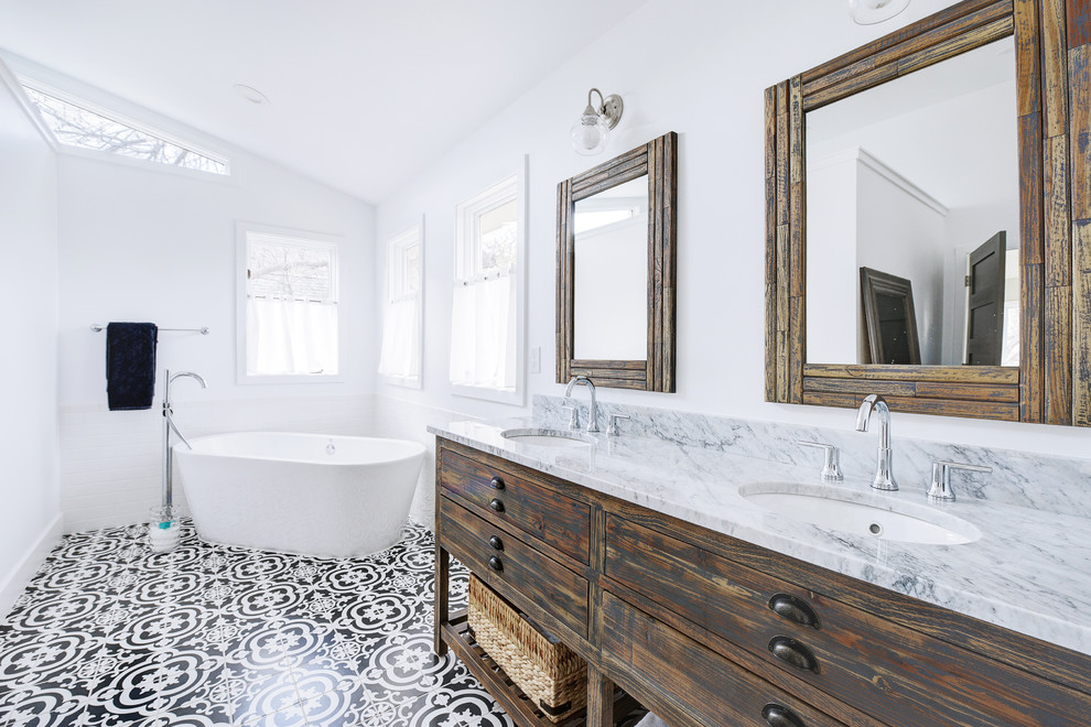 Large transitional master bathroom in Denver with flat-panel cabinets, distressed cabinets, a freestanding tub, a one-piece toilet, white tile, subway tile, white walls, ceramic floors, an undermount sink, marble benchtops, multi-coloured floor and white benchtops.