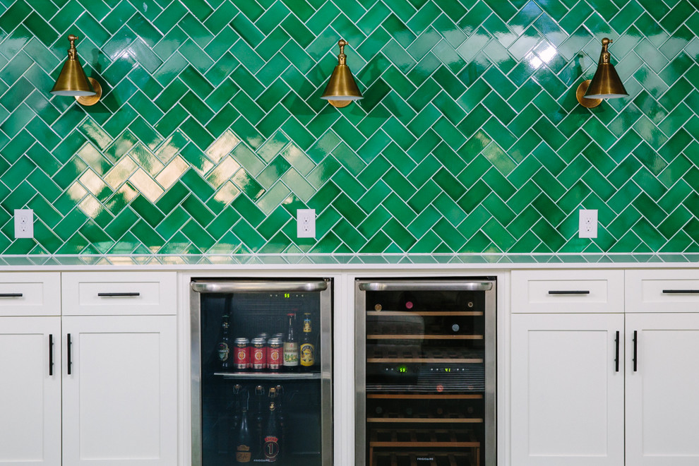 Southill - We brought to life an abandoned basement by adding in a bar featuring a wine fridge, green backsplash in a herringbone pattern, and brass task lamp sconces.