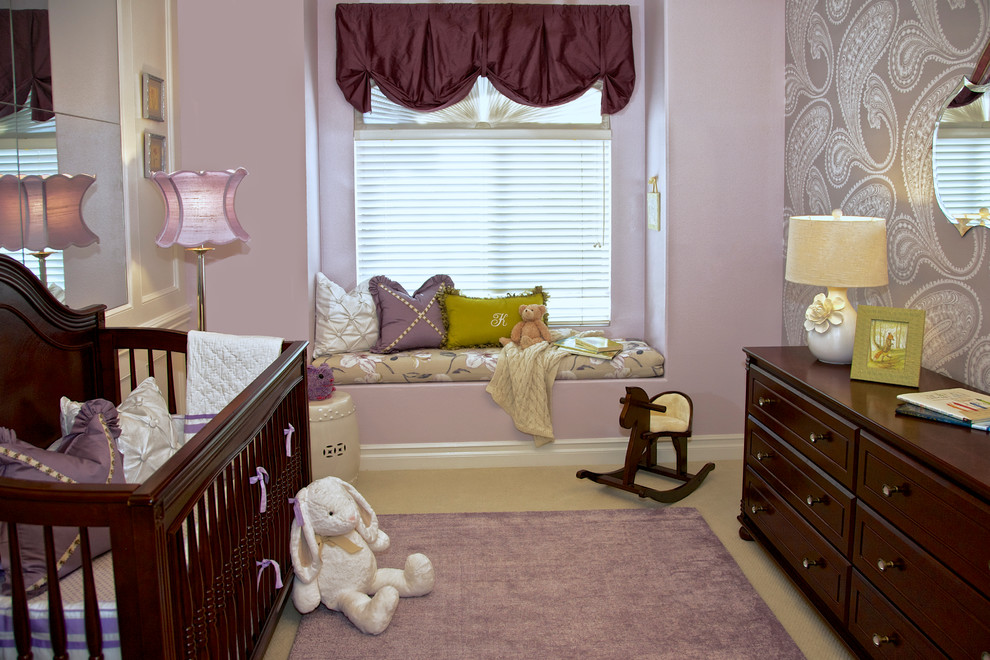 Photo of a traditional nursery for girls in Orange County with purple walls and carpet.