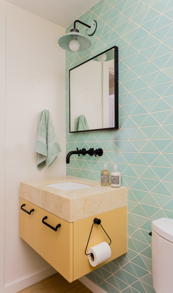 Photo of a small contemporary kids bathroom in Boston with yellow cabinets, a shower/bathtub combo, multi-coloured tile, ceramic tile, blue walls, light hardwood floors, beige floor, an open shower and yellow benchtops.