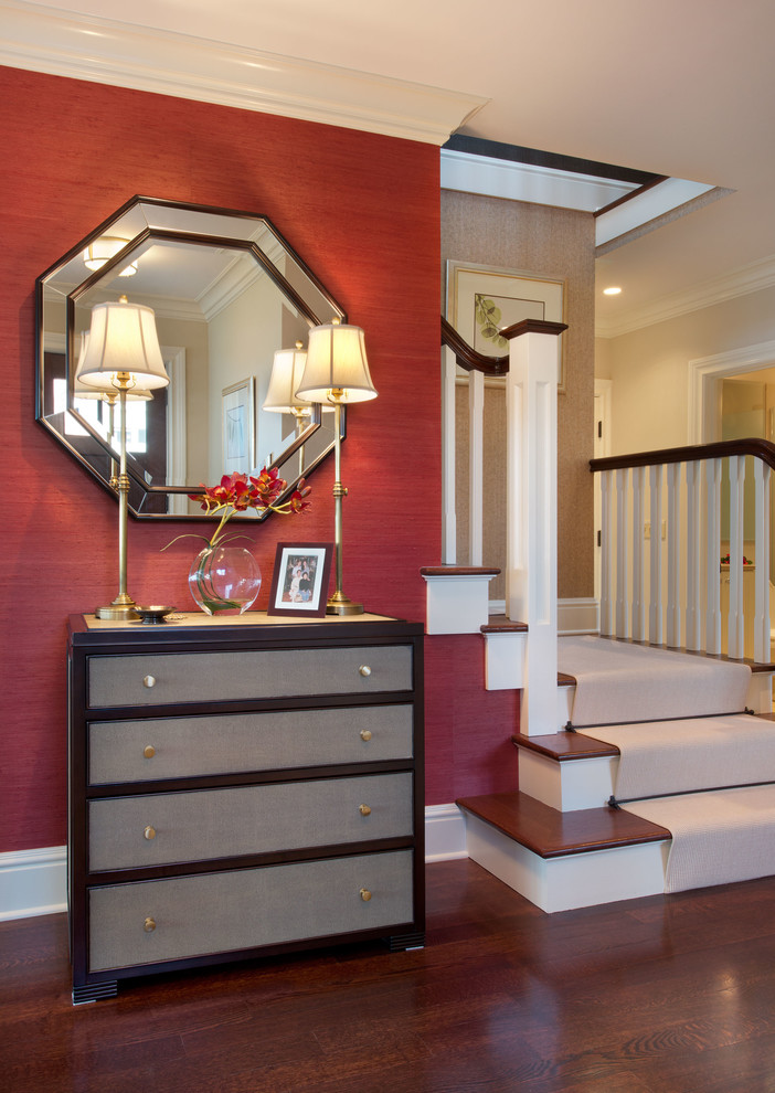 This is an example of a mid-sized eclectic foyer in New York with red walls, dark hardwood floors, a single front door, a dark wood front door and brown floor.