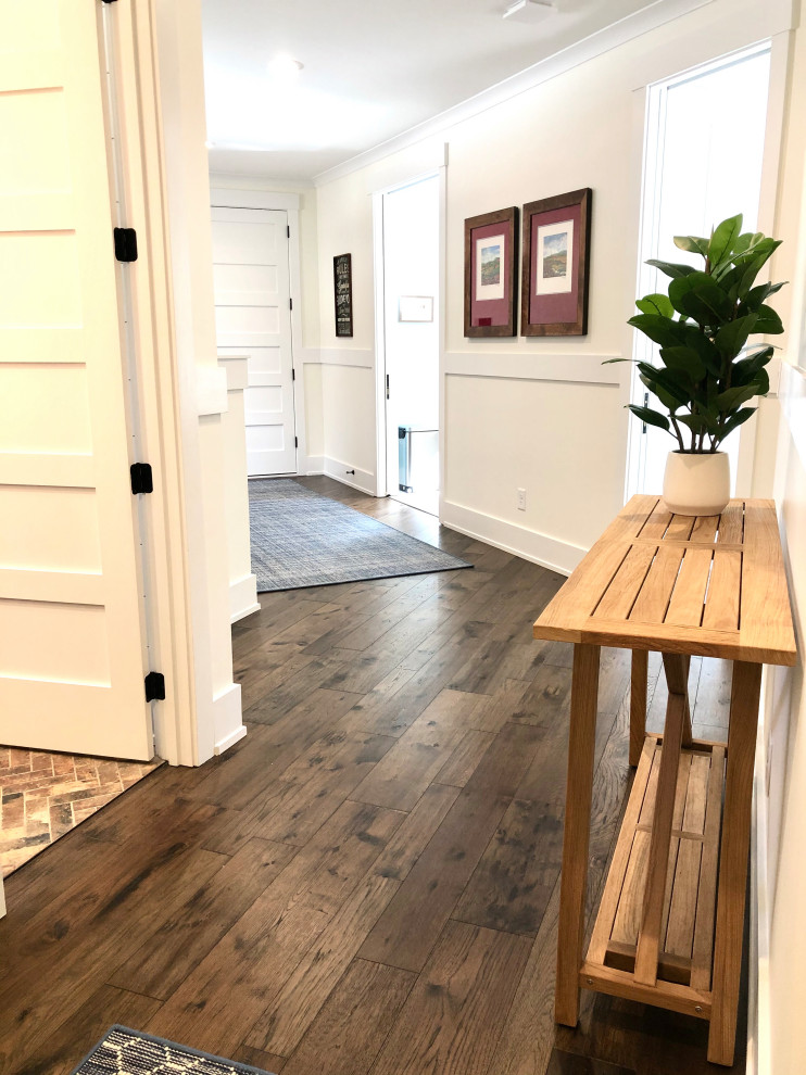 Cette photo montre un couloir chic de taille moyenne avec un mur blanc, parquet foncé, un sol marron, un plafond en lambris de bois et boiseries.