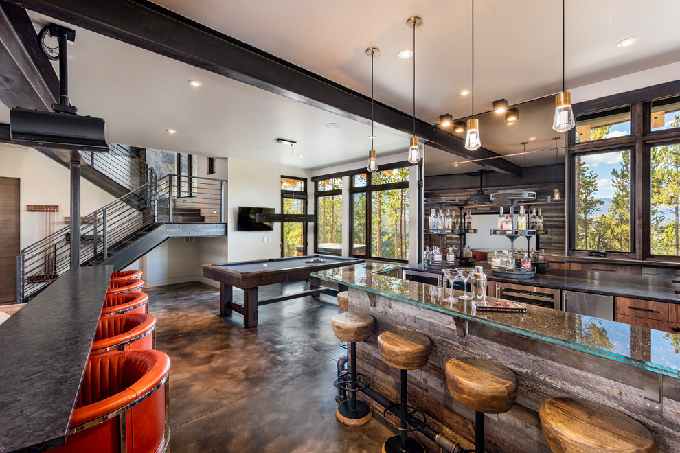 Country u-shaped seated home bar in Denver with flat-panel cabinets, medium wood cabinets, glass benchtops, brown splashback, concrete floors, brown floor and grey benchtop.