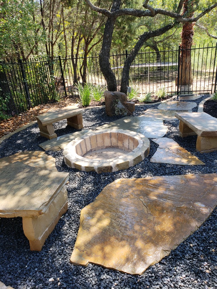 Inspiration for a mid-sized modern backyard shaded xeriscape in Austin with a fire feature and natural stone pavers.