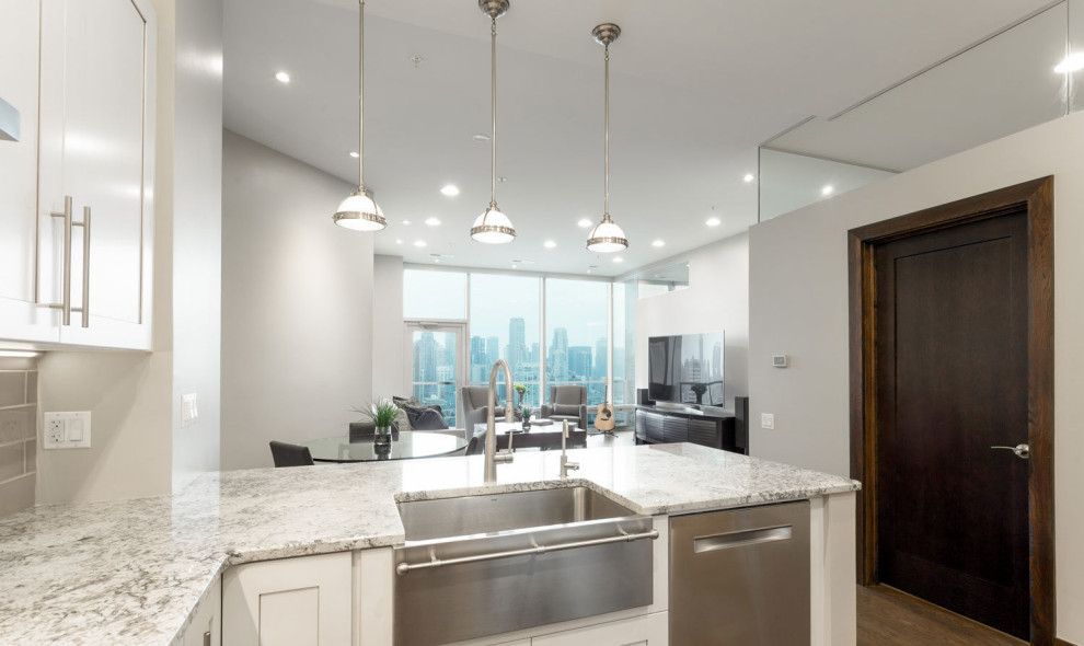 Mid-sized transitional l-shaped eat-in kitchen in Chicago with an undermount sink, shaker cabinets, white cabinets, granite benchtops, stainless steel appliances, medium hardwood floors and with island.