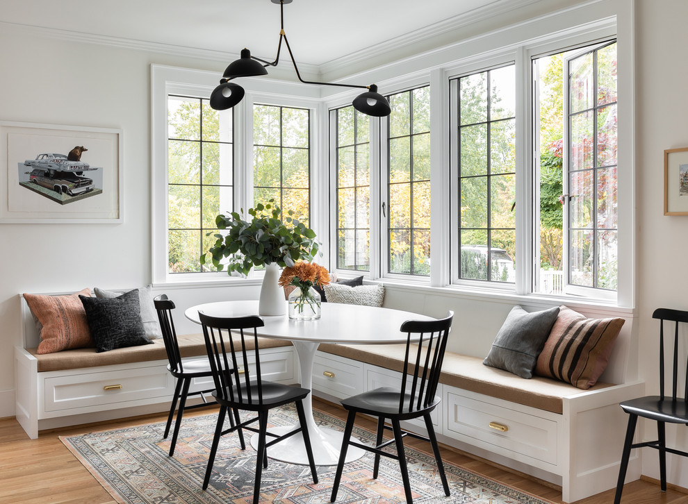 Inspiration for a transitional dining room in Portland with white walls, medium hardwood floors and brown floor.