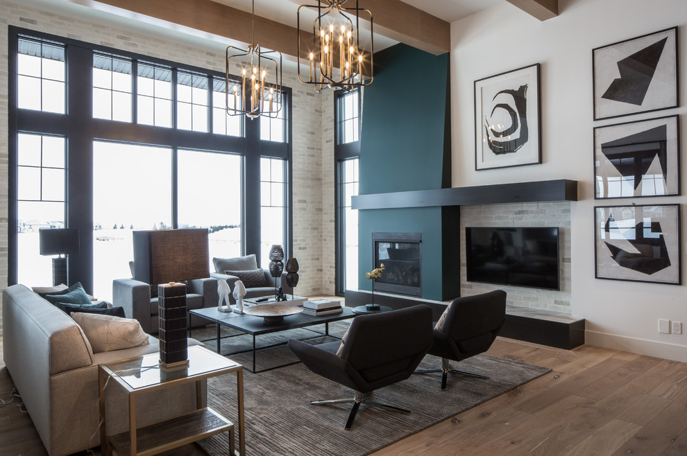 Example of a large trendy open concept medium tone wood floor and brown floor family room design in Calgary with white walls, a standard fireplace and a media wall