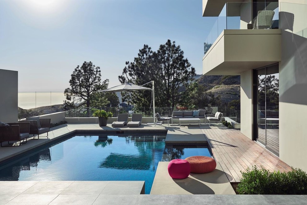 Large contemporary backyard rectangular lap pool in Los Angeles with a hot tub and concrete pavers.