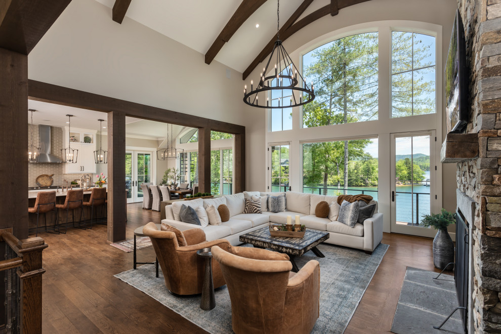 Inspiration for a large craftsman open concept medium tone wood floor, brown floor and vaulted ceiling family room remodel in Other with white walls, a standard fireplace, a stone fireplace and a wall-mounted tv