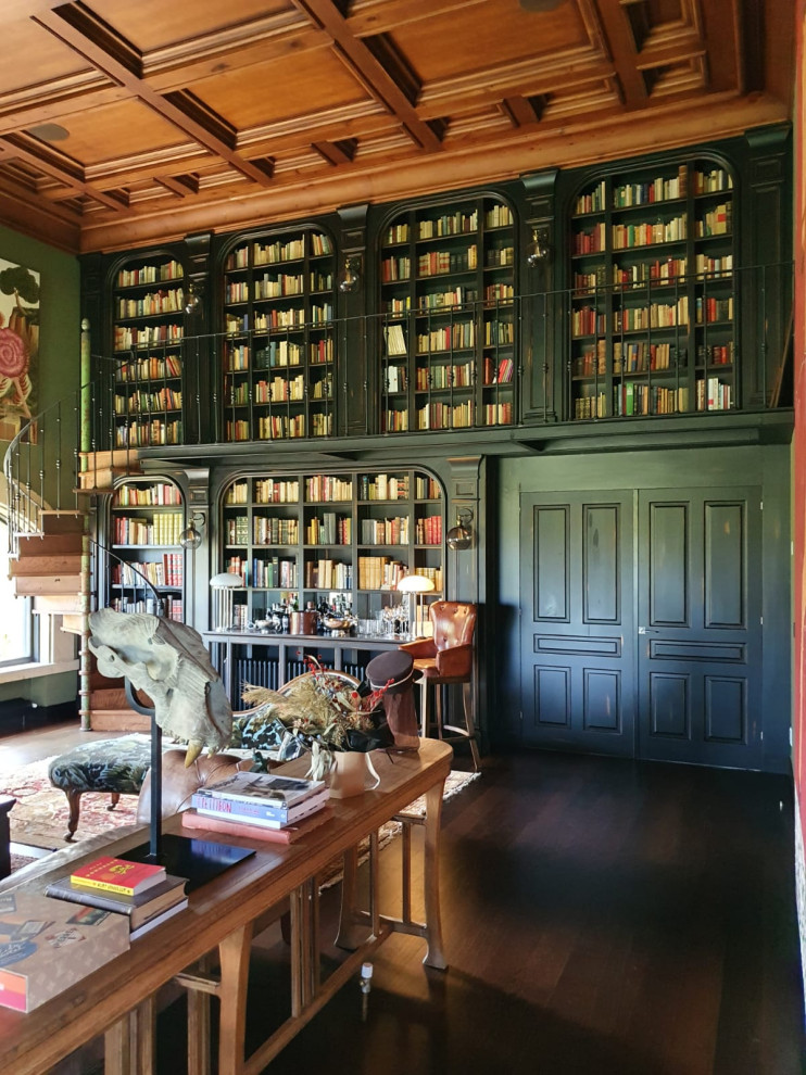 Exempel på ett stort klassiskt vardagsrum, med ett bibliotek, gröna väggar, mörkt trägolv, en standard öppen spis, en spiselkrans i sten och brunt golv