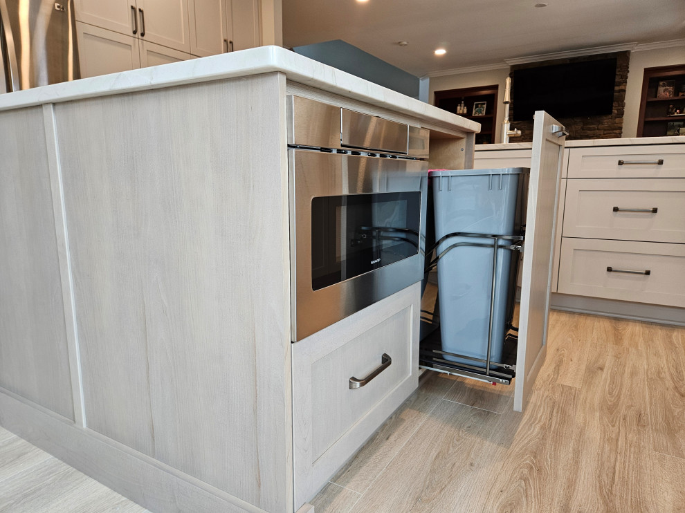 Large transitional l-shaped eat-in kitchen photo in Nashville with shaker cabinets, quartz countertops and an island