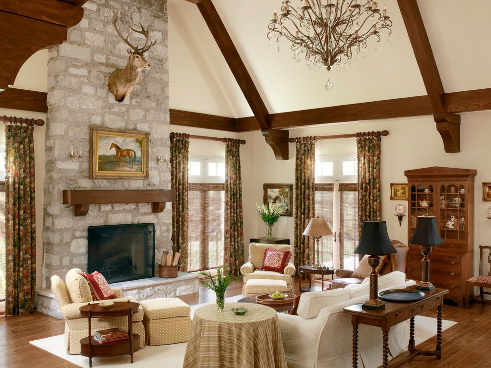 This is an example of a traditional formal open concept living room in St Louis with beige walls, medium hardwood floors, a standard fireplace and a stone fireplace surround.