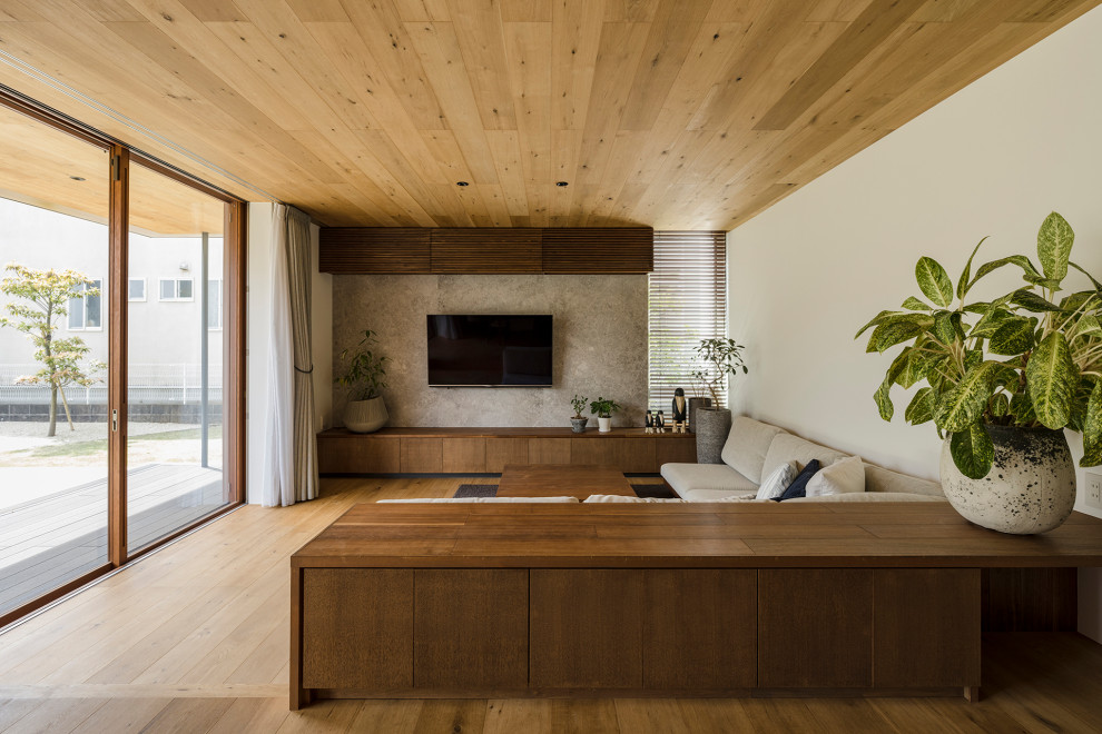 На фото: гостиная комната в стиле модернизм с белыми стенами, паркетным полом среднего тона, телевизором на стене, коричневым полом и деревянным потолком