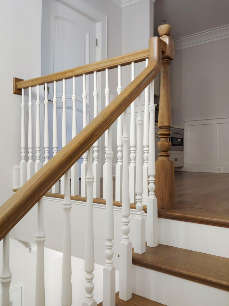 Cette image montre un escalier peint traditionnel en U de taille moyenne avec des marches en bois, un garde-corps en bois et boiseries.