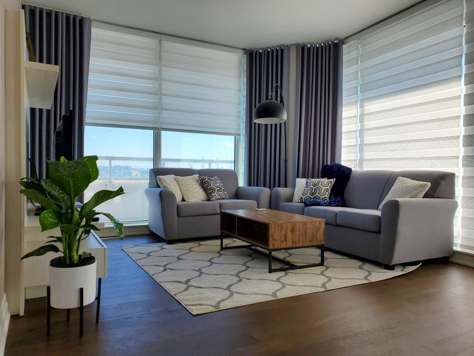 Foto de salón abierto minimalista extra grande con paredes beige, suelo de madera en tonos medios y televisor independiente