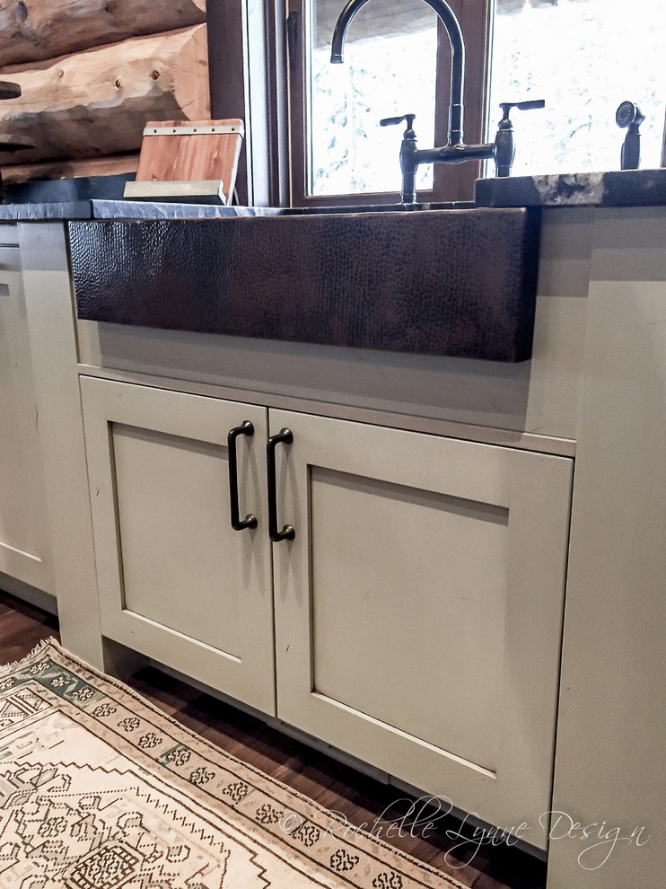 Mountain style l-shaped medium tone wood floor open concept kitchen photo in Calgary with a farmhouse sink, shaker cabinets, distressed cabinets, granite countertops, multicolored backsplash and two islands